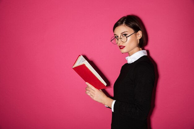 Portrait of a beautiful young businesswoman reading a book
