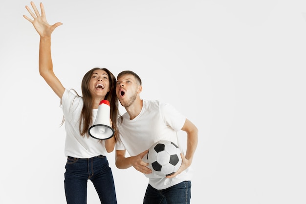 Free photo portrait of beautiful young couple football or soccer fans on white studio wall