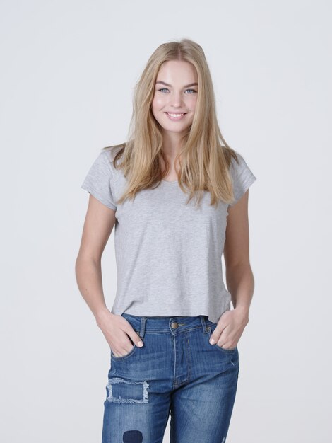 Portrait of a  beautiful young smiling  girl. Female face with toothy smile. Attractive blond girl poses at studio in a casual t shirt