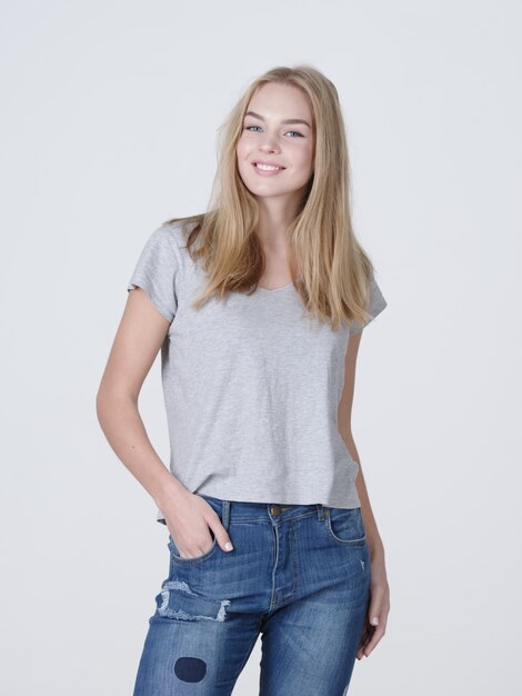 Portrait of a  beautiful young smiling  girl. Female face with toothy smile. Attractive blond girl poses at studio in a casual t shirt