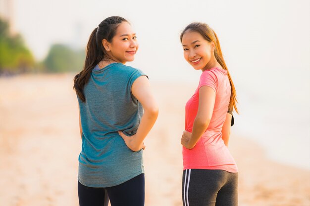 Portrait beautiful young sport asian woman running and exercise on the beach near sea and ocean at sunrise or sunset time