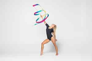 Free photo the portrait of beautiful young woman gymnast training calilisthenics exercise with ribbon. art gymnastics concept.