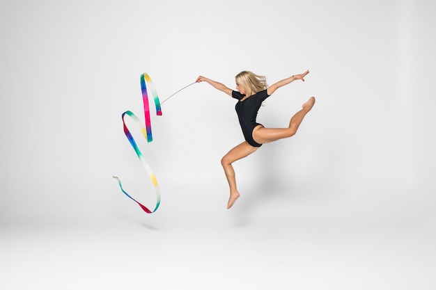 リボン付きの美しい若い女性の体操選手トレーニングcalilisthenics運動の肖像画。アート体操のコンセプトです。