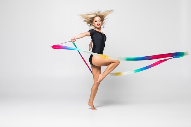 The portrait of beautiful young woman gymnast training calilisthenics exercise with ribbon. Art gymnastics concept.