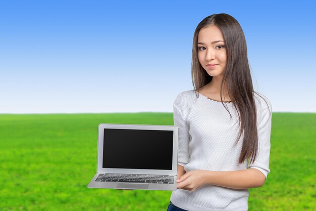 Portrait of beautiful young woman holding laptop isolated