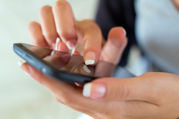 Foto gratuita ritratto di bella giovane donna a casa con il cellulare.