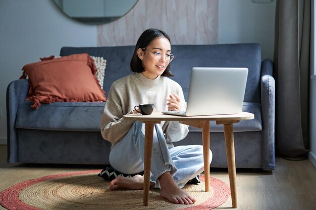 彼女のラップトで自宅のフリーランスから離れた場所で働く美しい若い女性専門家の肖像画