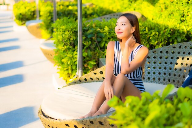 Portrait beautiful young woman relax smile leisure on vacation around swimming pool in resort hotel