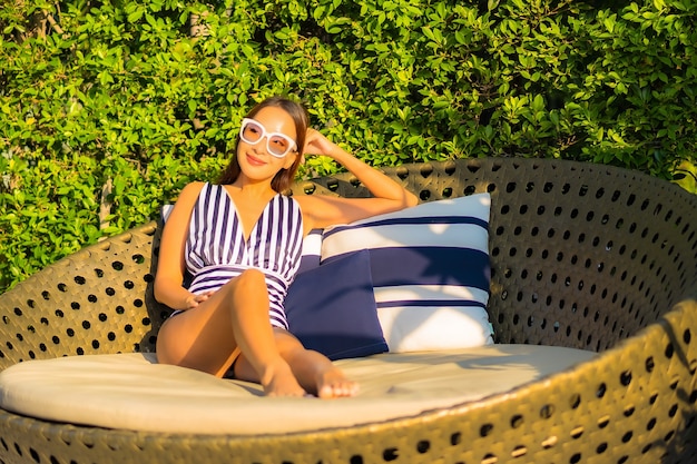 Portrait beautiful young woman relax smile leisure on vacation around swimming pool in resort hotel