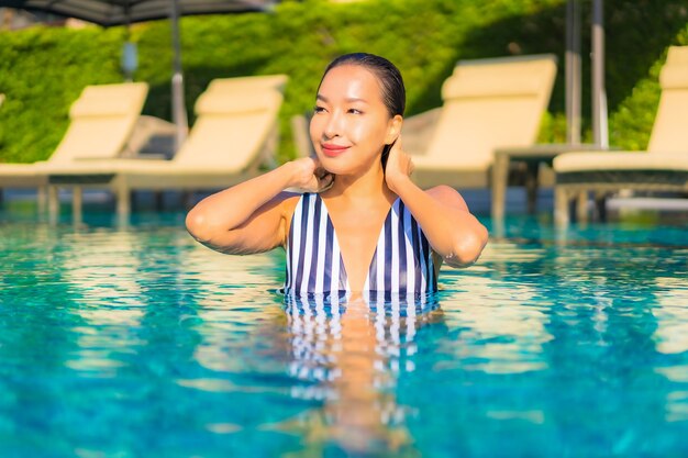 Portrait beautiful young woman relax smile leisure on vacation around swimming pool in resort hotel