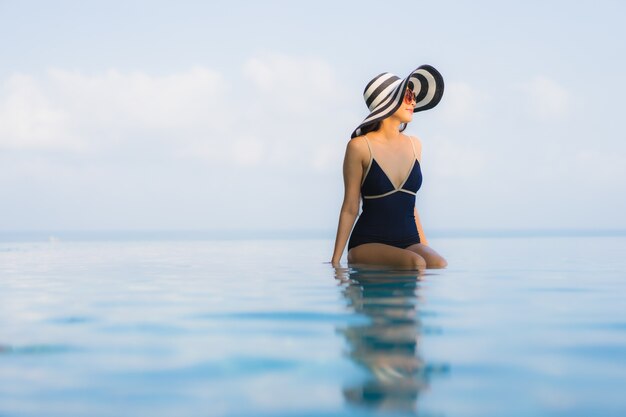 Portrait of beautiful young woman relaxing around swimming pool in hotel resort