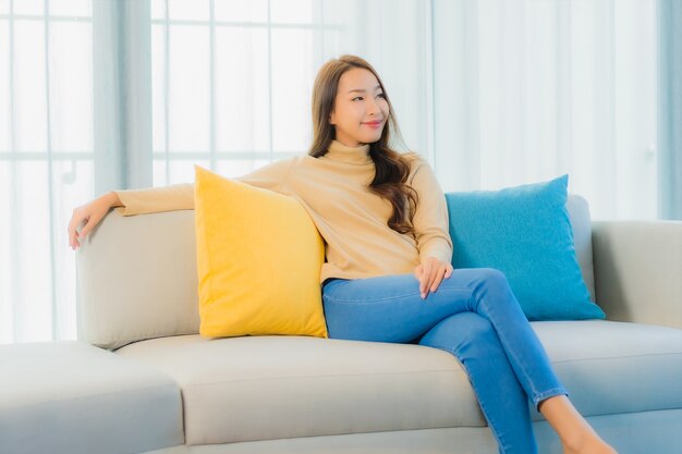 Portrait of beautiful young woman on sofa in living room