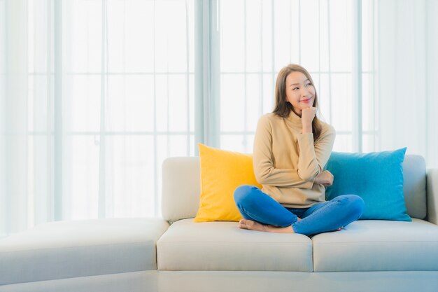 Portrait of beautiful young woman on sofa in living room