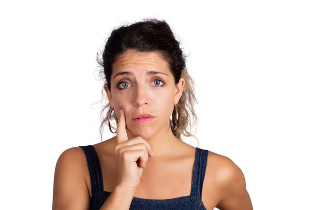 Portrait of beautiful young woman thinking and planning something in studio. Isolated white background.