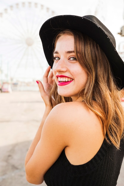 Portrait of beautiful young woman wearing black hat