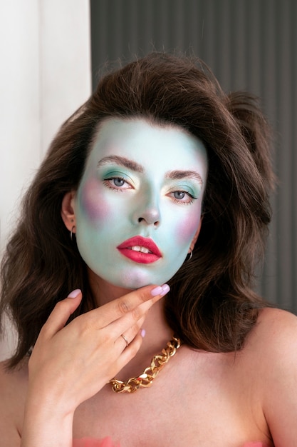 Portrait of beautiful young woman with colorful face make-up