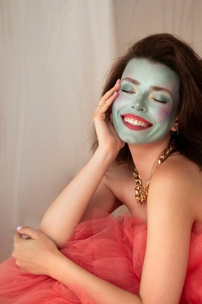 Portrait of beautiful young woman with colorful face make-up