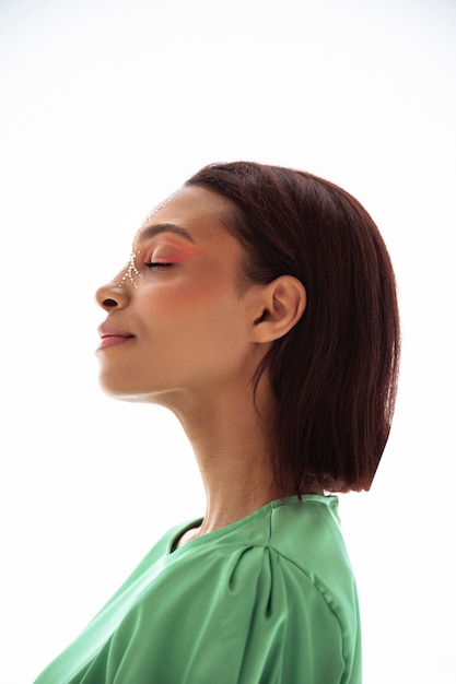 Portrait of beautiful young woman with colorful face make-up