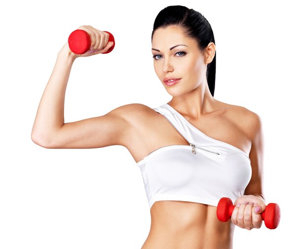 Portrait of beautiful young woman with dumbbells -  grey studio background. Healthy lifestyle concept.