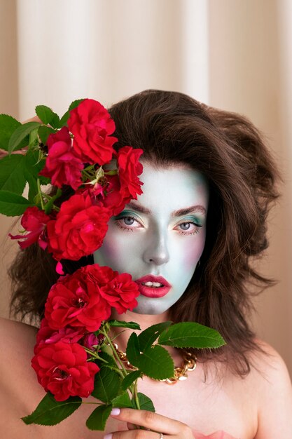 얼굴 페인트와 꽃을 가진 아름다운 젊은 여성의 초상화