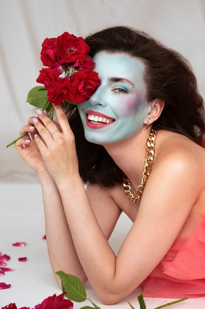 얼굴 페인트와 꽃을 가진 아름다운 젊은 여성의 초상화