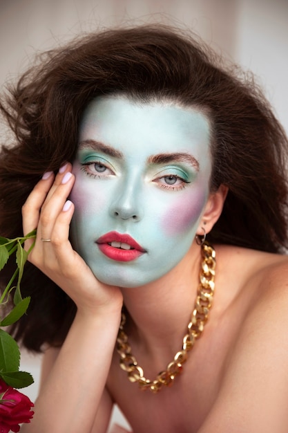 Portrait of beautiful young woman with face paint and flowers