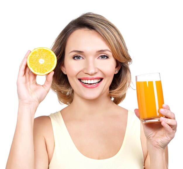 Portrait of a beautiful young woman with a glass of juice and orange - isolated on white.