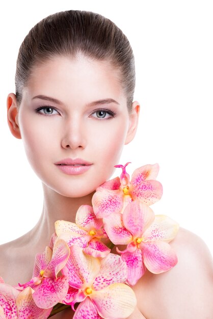 Portrait of beautiful young woman with healthy skin and pink flowers on body - isolated on white