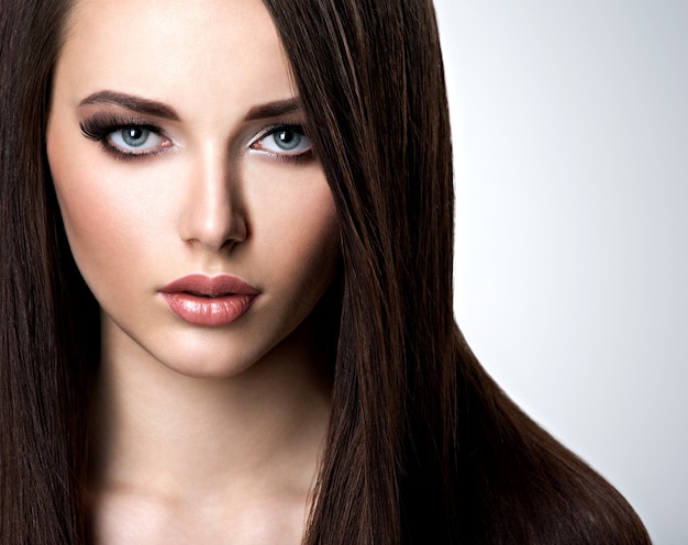 Portrait of beautiful young woman with long straight  hair at studio
