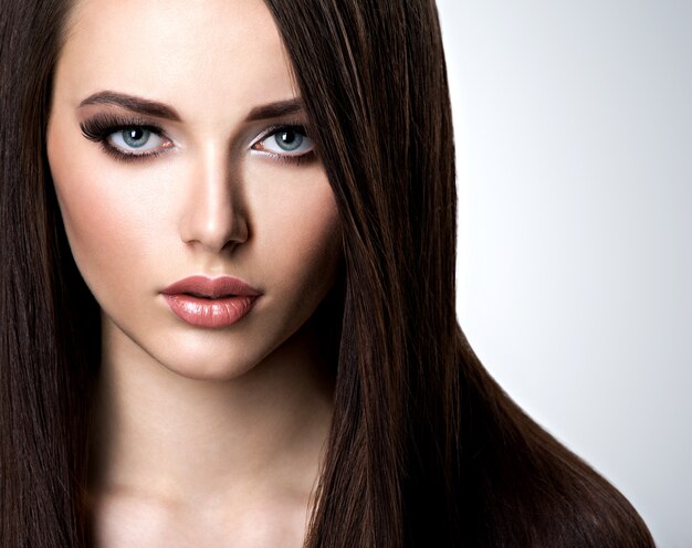 Портрет красивой молодой женщины с длинными прямыми волосами в студии
