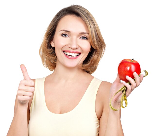 Portrait of a beautiful young woman with a measuring tape and apple - isolated on white.