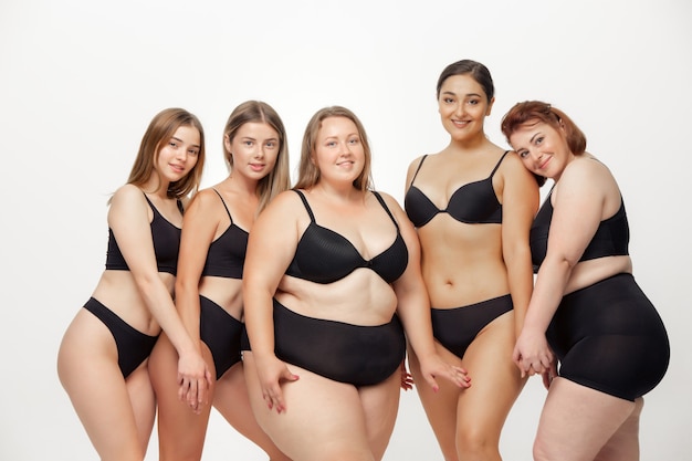 Portrait of beautiful young women with different shapes posing on white