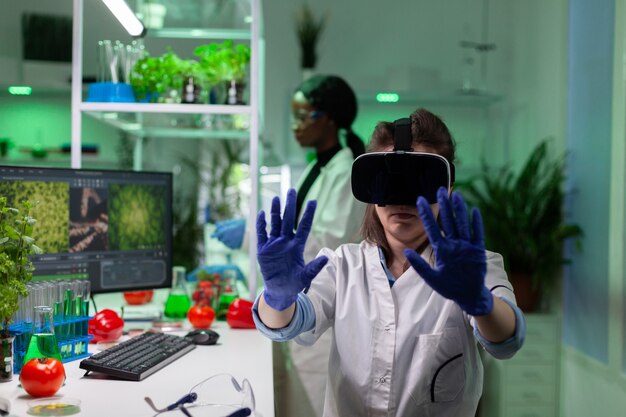 Portrait of biologist researcher woman analyzing virtual gmo plants expertise