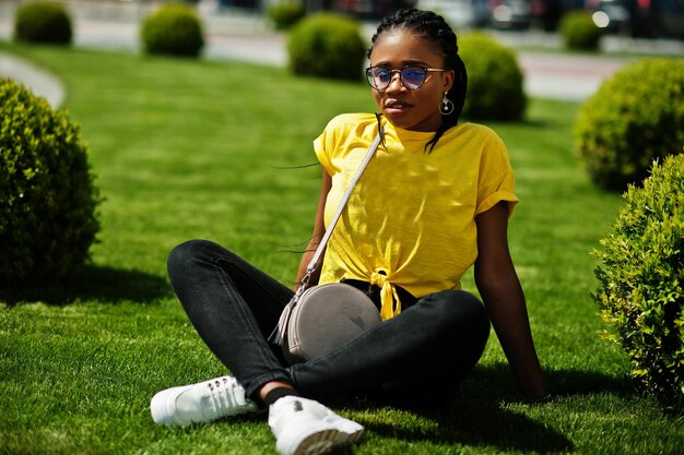 Портрет черной афроамериканки в желтой футболке и очках