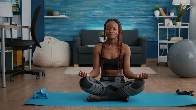 朝の呼吸トレーニングをしている床に蓮華座に座っている黒人女性の肖像画