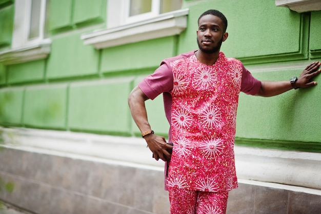 Free photo portrait of a black young man wearing african traditional red colorful clothes