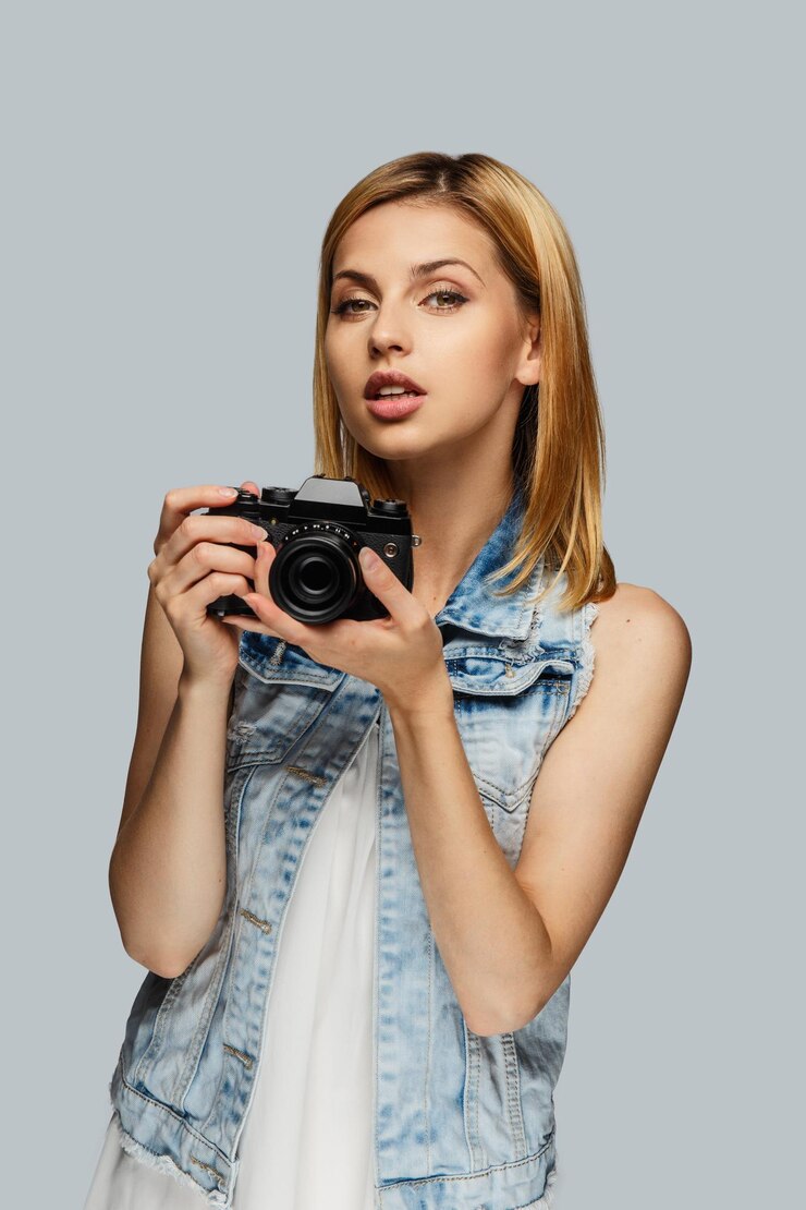Free Photo portrait of blond female photographer isolated on grey background.