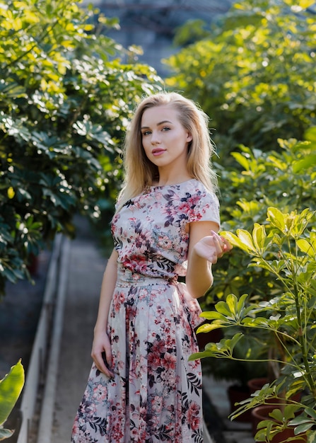 Portrait of a blonde beautiful woman in a greenhouse