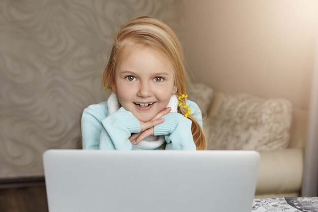 Portrait of blonde European little girl with messy ponytail having happy and cheerful expression