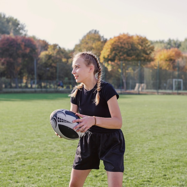 Portrait of blonde girl holding a rugby ball