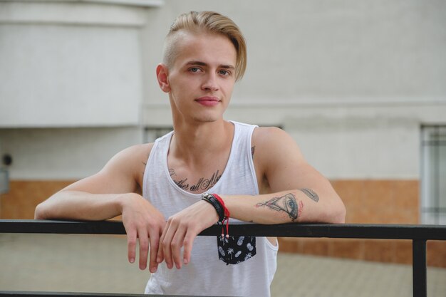 Ragazzo biondo hipster ritratto con tatuaggi e capelli alla moda