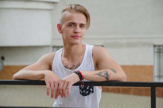 Portrait blonde hipster boy with tattoos and stylish hair