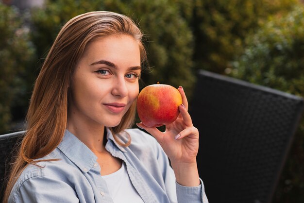 Portrait of blonde woman holding a apple