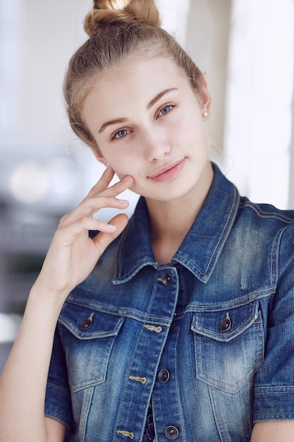 Portrait of a blue eyed blond female dressed in a denim jacket.