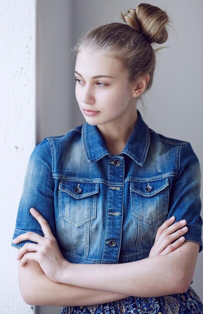 Portrait of a blue eyed blond female dressed in a denim jacket.