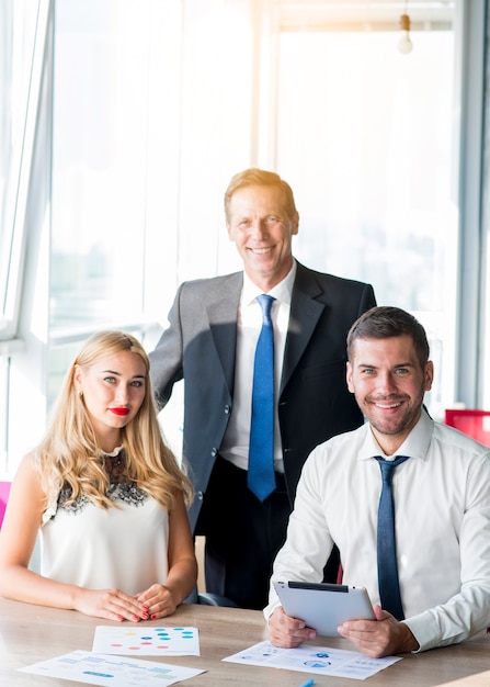 Portrait of boss with his two colleagues at workplace in the office