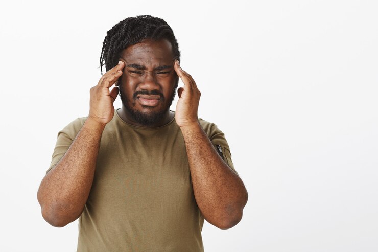 Free Photo portrait of bothered guy in a brown t-shirt posing against the white wall