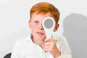 Free photo portrait of boy covered eye with occluder in optics clinic