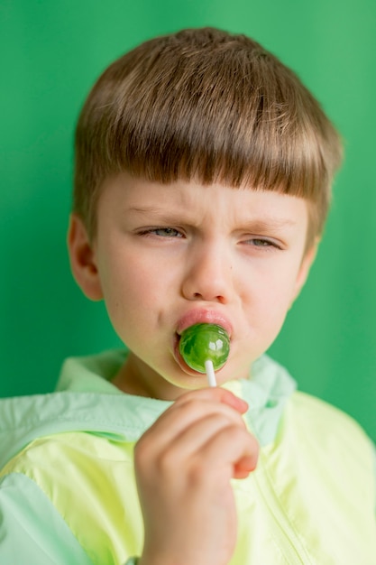 Free photo portrait boy eating lollipop