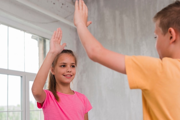 Portrait of a boy and girl giving high five